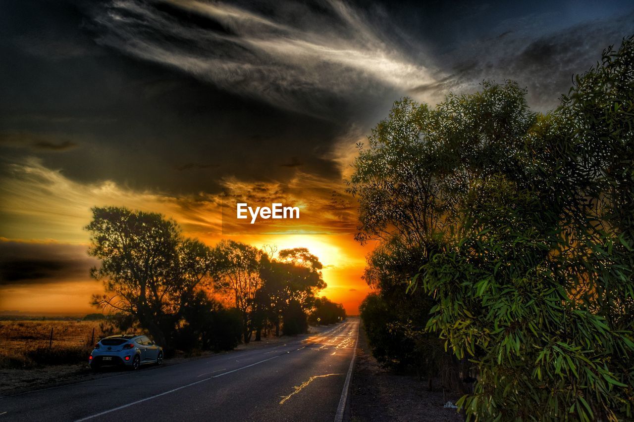 VIEW OF ROAD AGAINST CLOUDY SKY DURING SUNSET