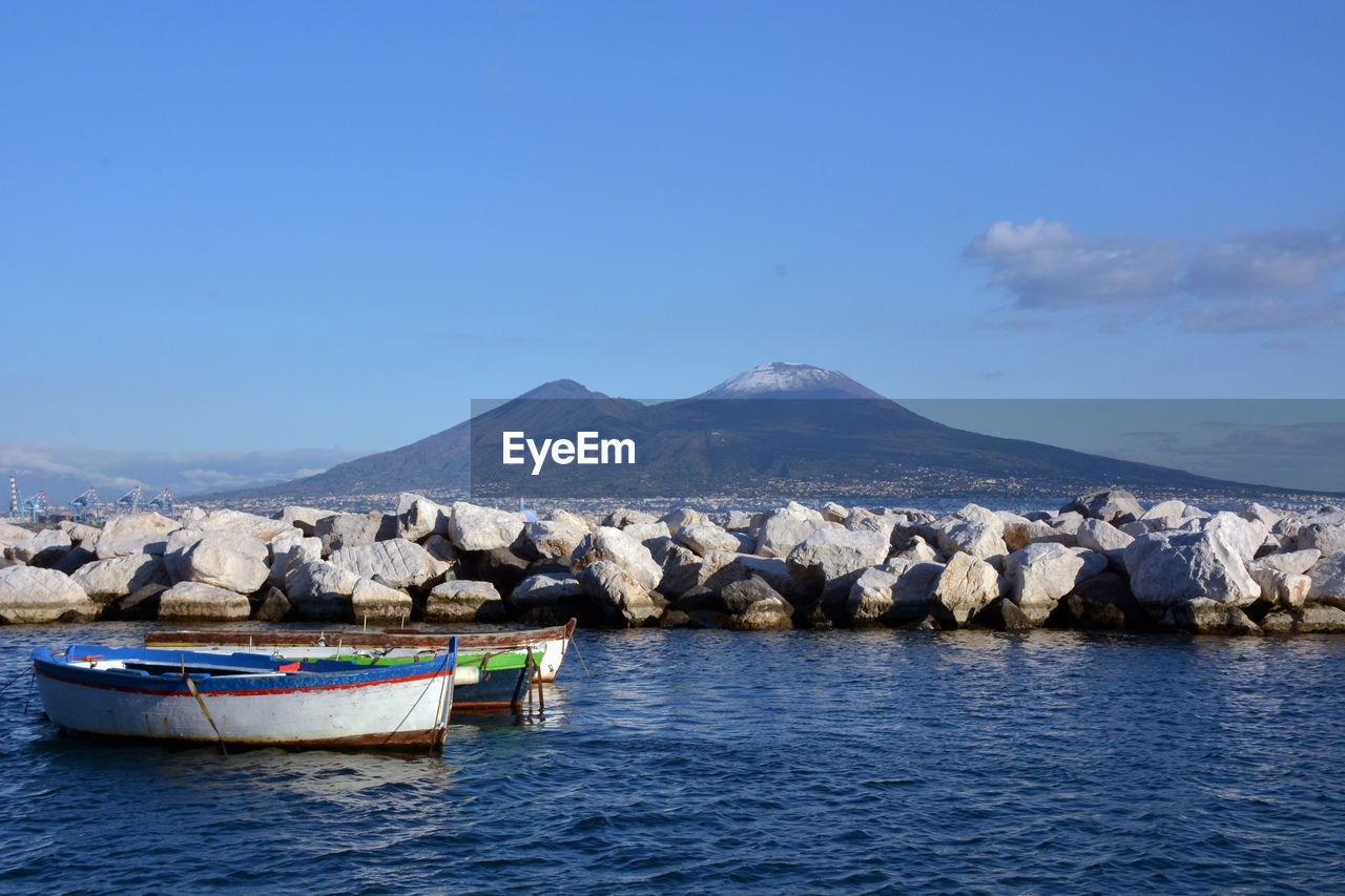 Scenic view of sea and mountains against blue sky