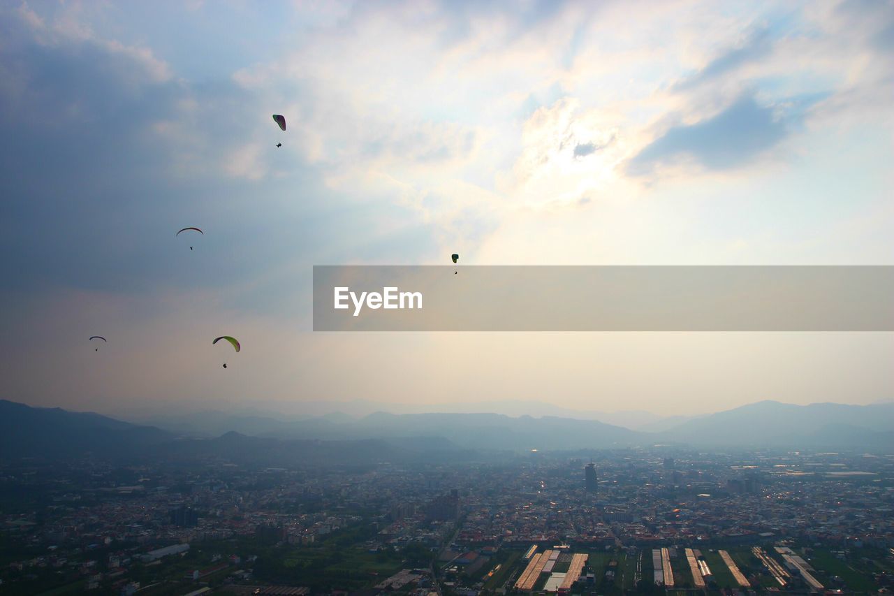 AERIAL VIEW OF CITYSCAPE AGAINST CLOUDY SKY