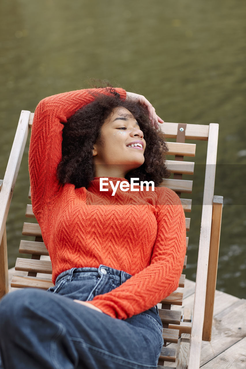 portrait of young woman sitting on railing