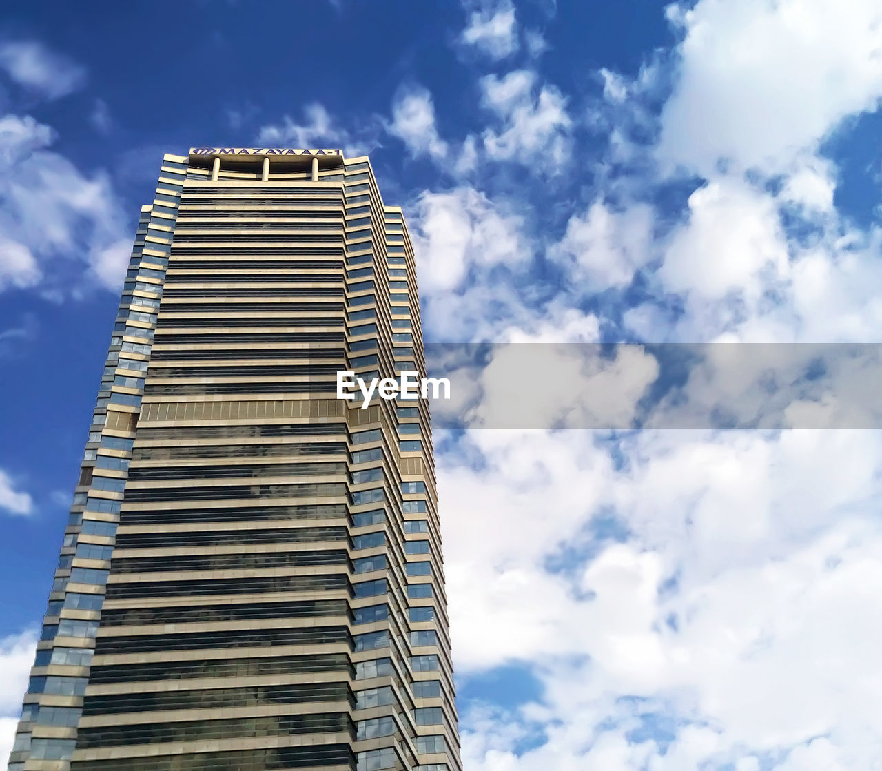 Low angle view of modern building against cloudy sky