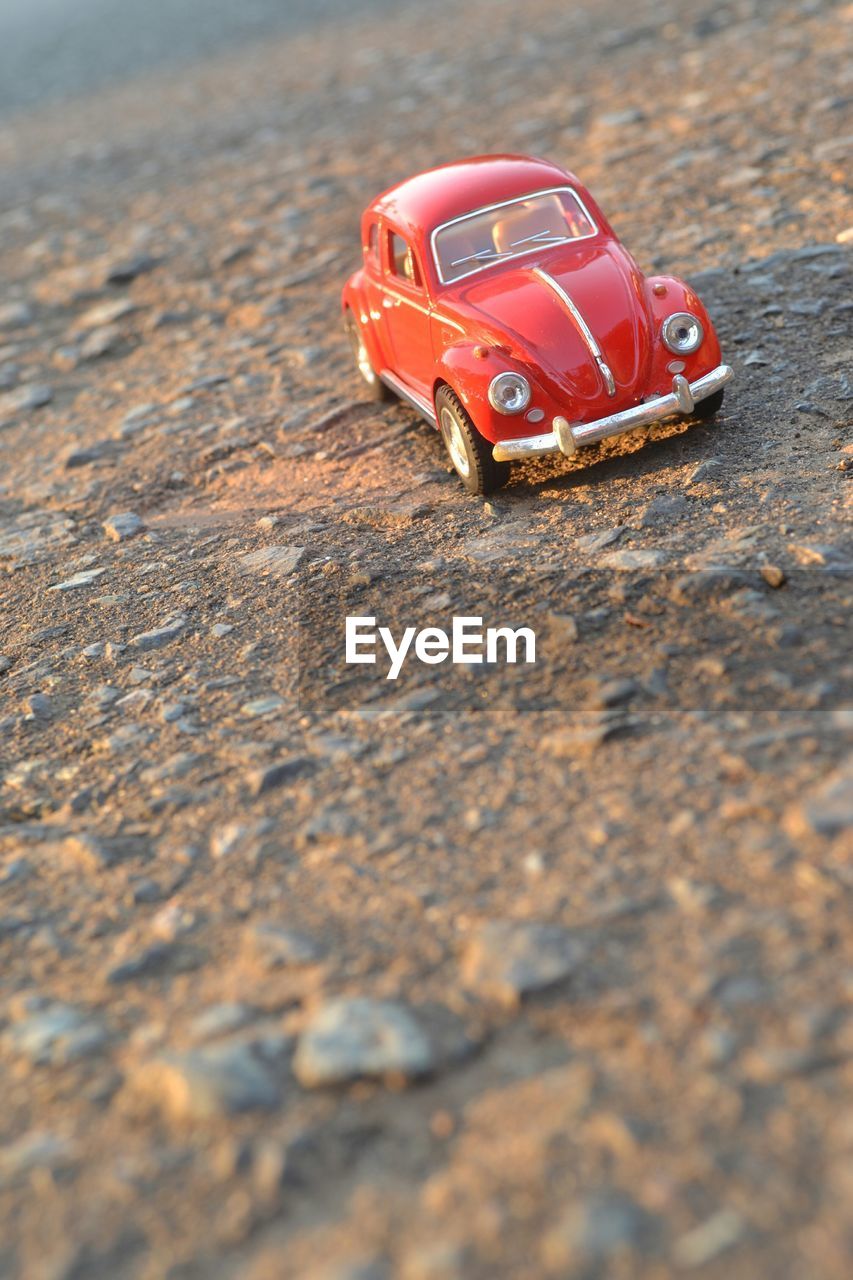 CLOSE-UP OF SMALL TOY CAR ON DIRT