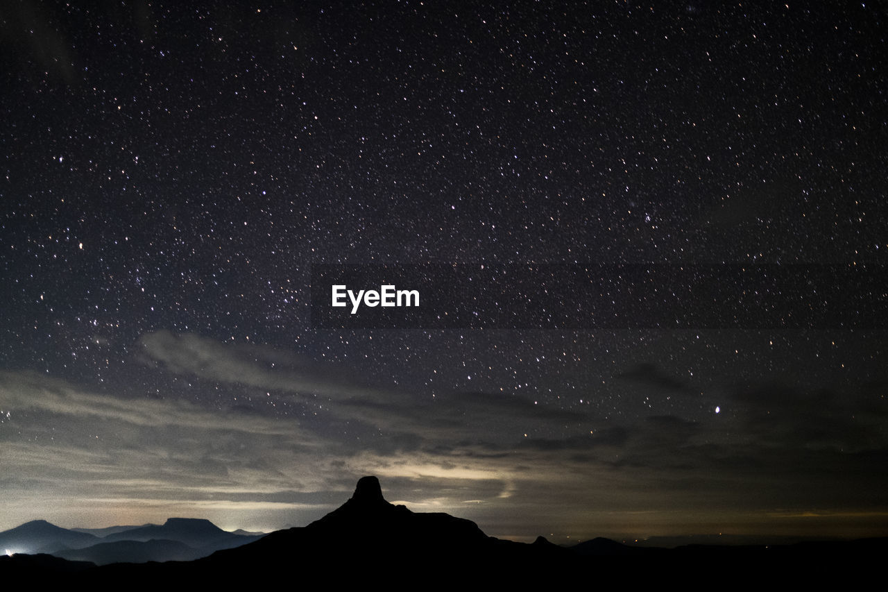 Scenic view of mountains  with stars against sky at night 