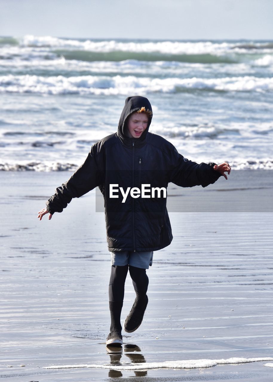 Full length portrait of boy standing on beach