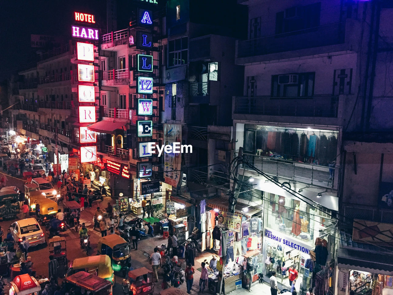 GROUP OF PEOPLE IN ILLUMINATED CITY