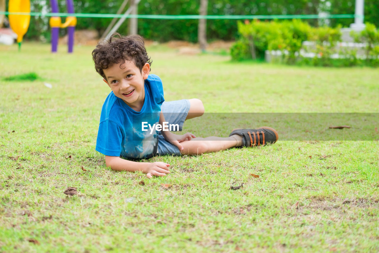 Smiling boy looking away on field