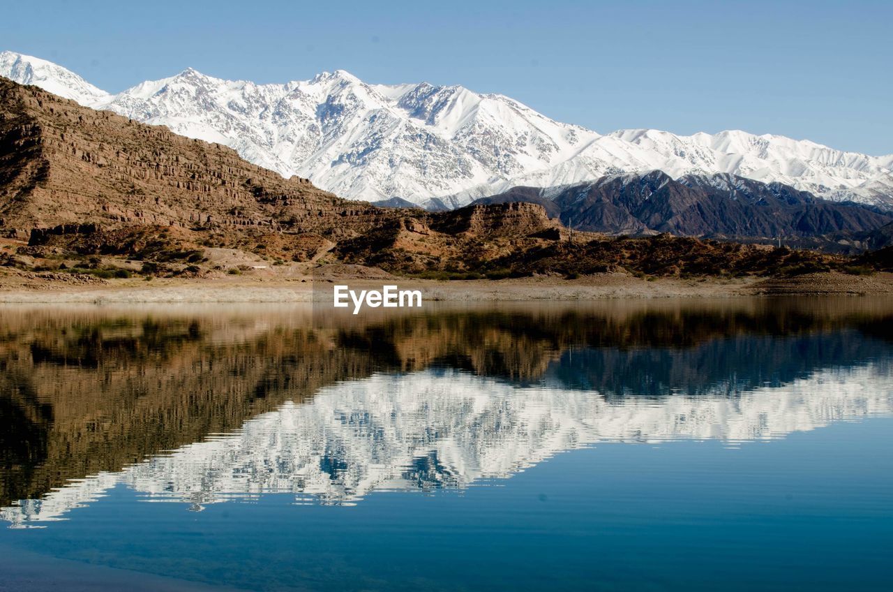 Scenic view of lake and snowcapped mountains against sky