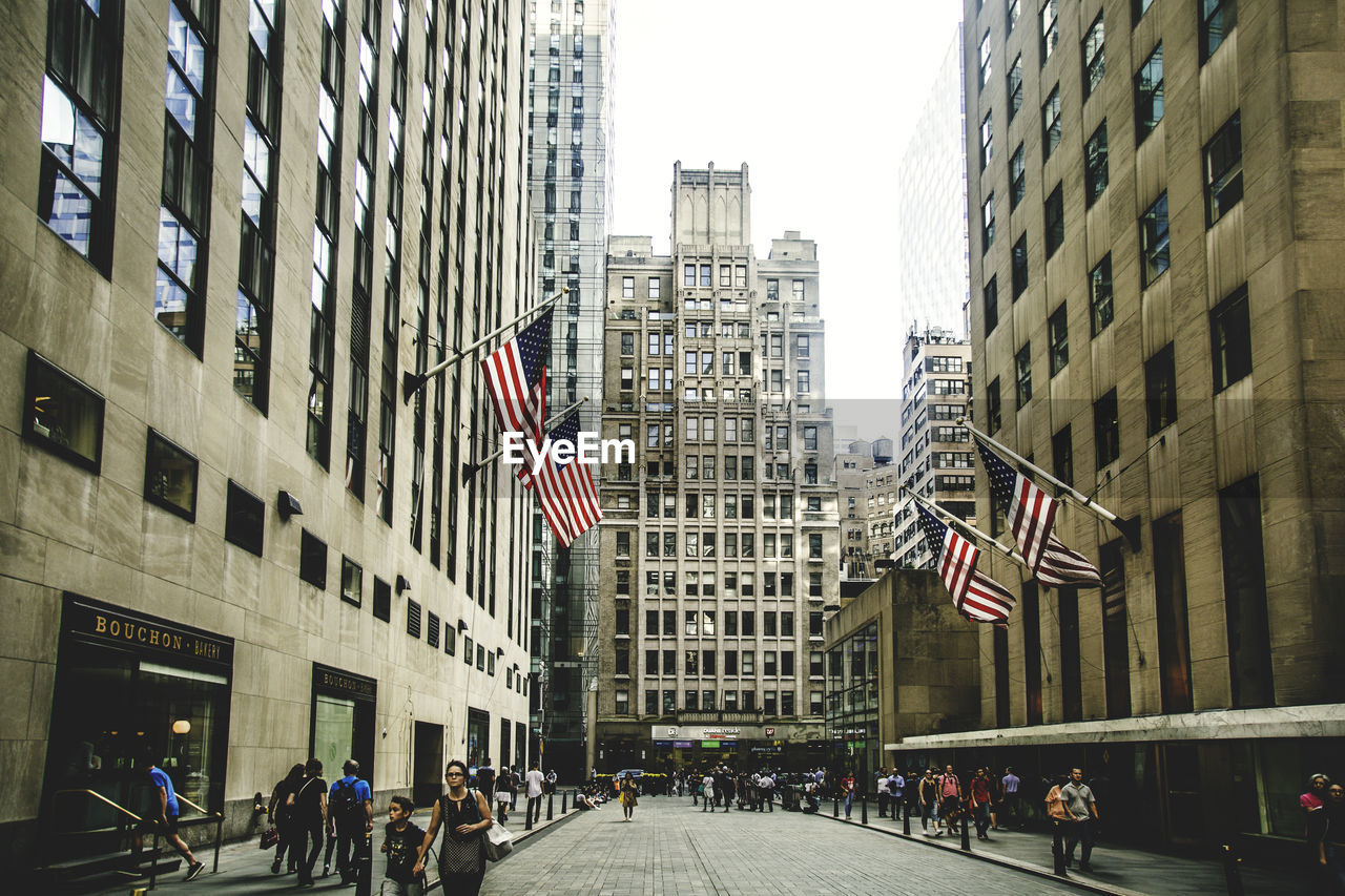 PEOPLE ON STREET AMIDST BUILDINGS