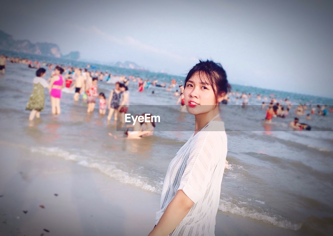 WOMAN STANDING AT BEACH