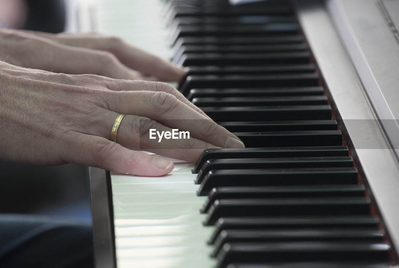 MAN PLAYING PIANO KEYS AT HOME