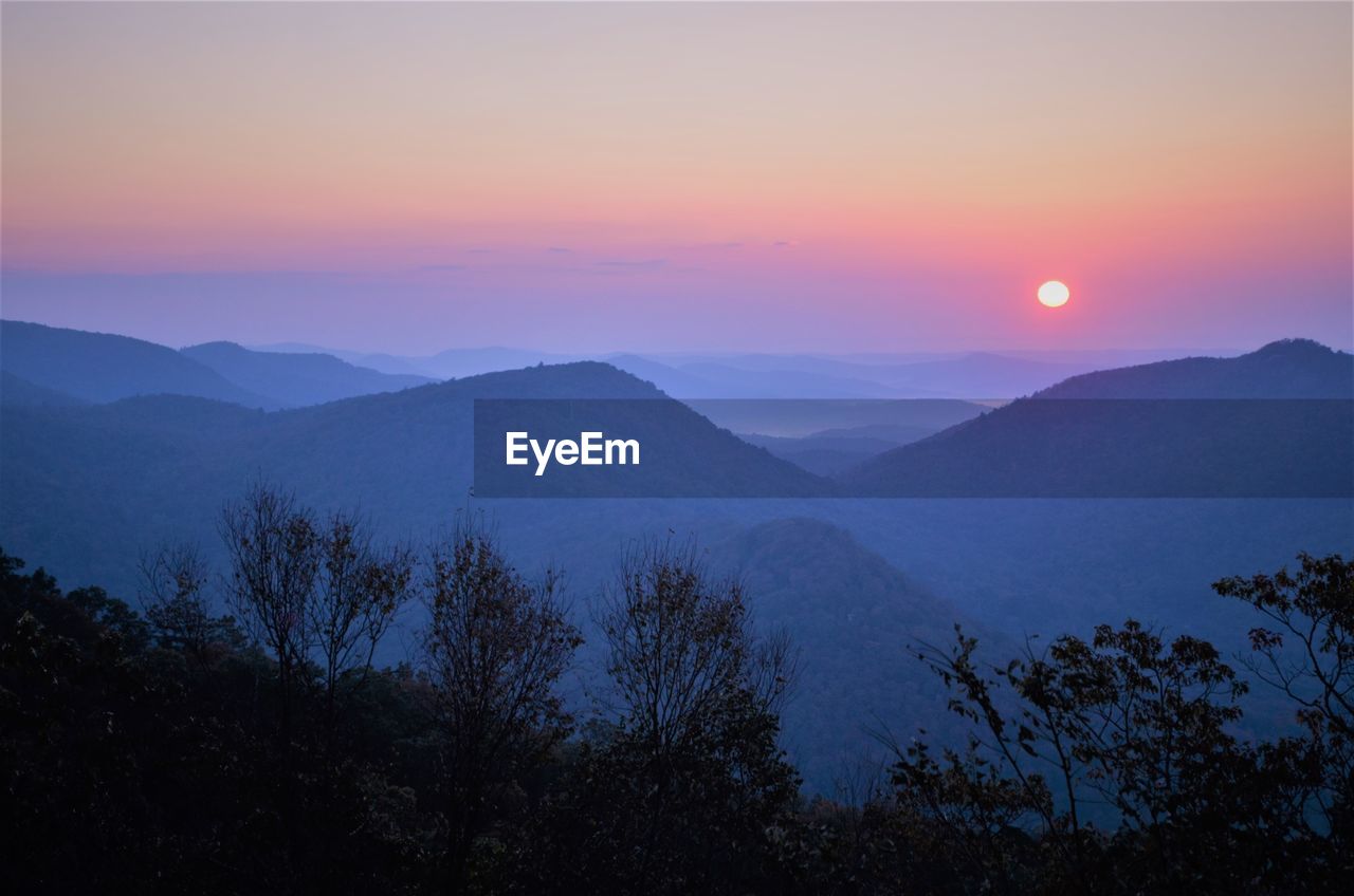 Scenic view of mountains against sky at sunset