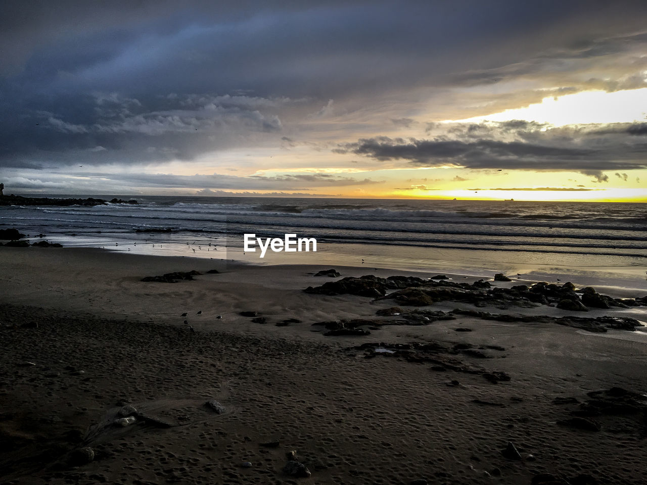 SCENIC VIEW OF BEACH AT SUNSET