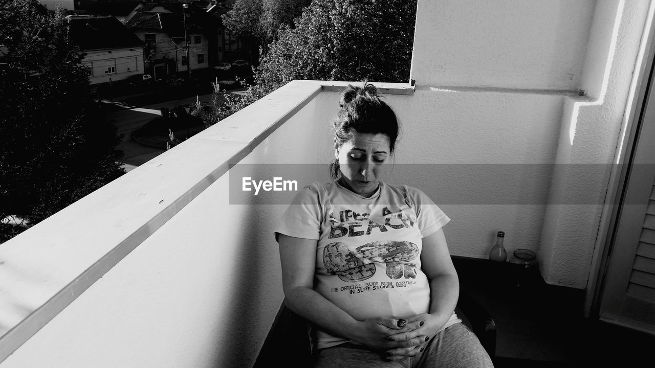 Pregnant woman sitting in balcony