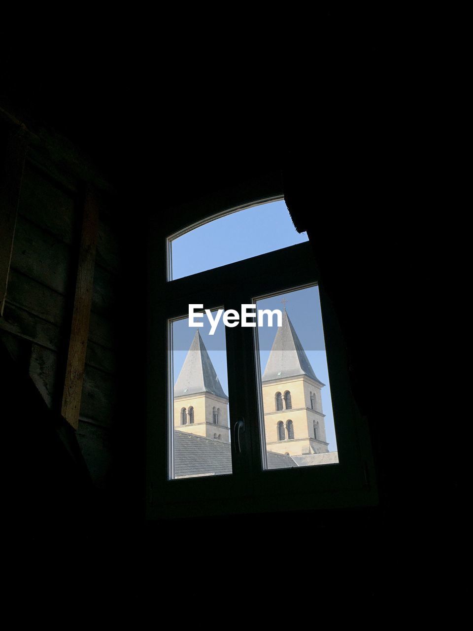 Low angle view of church tower seen through window