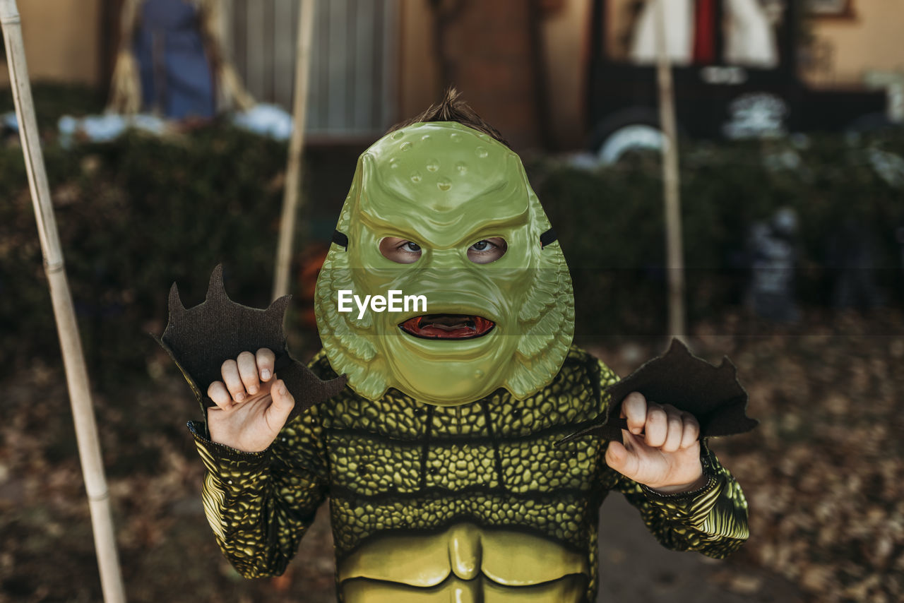 Portrait of boy dressed as sea monster posing in costume at halloween