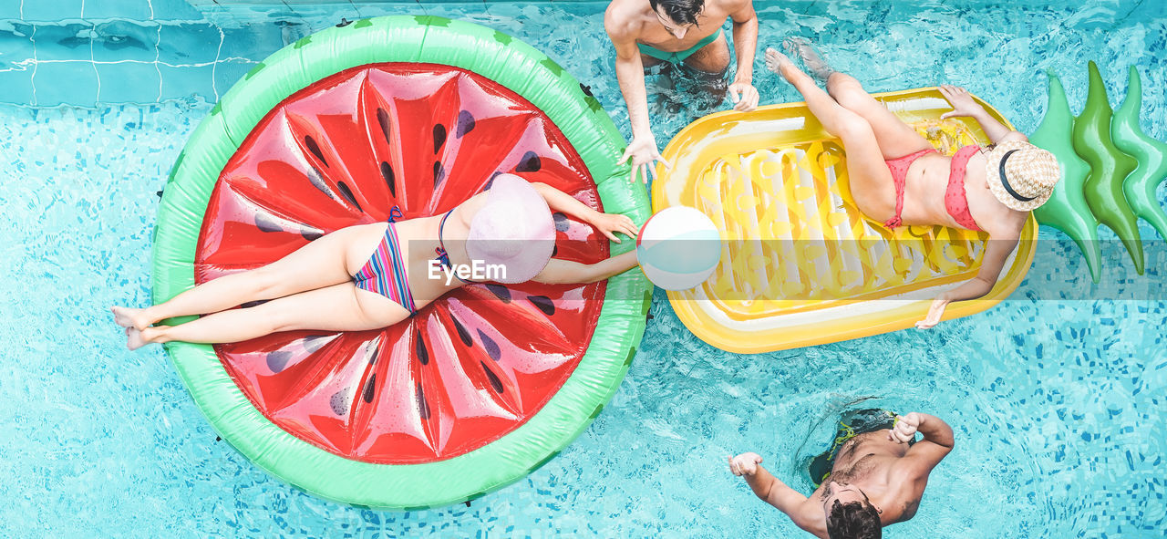 High angle view of people with inflatable rafts in swimming pool