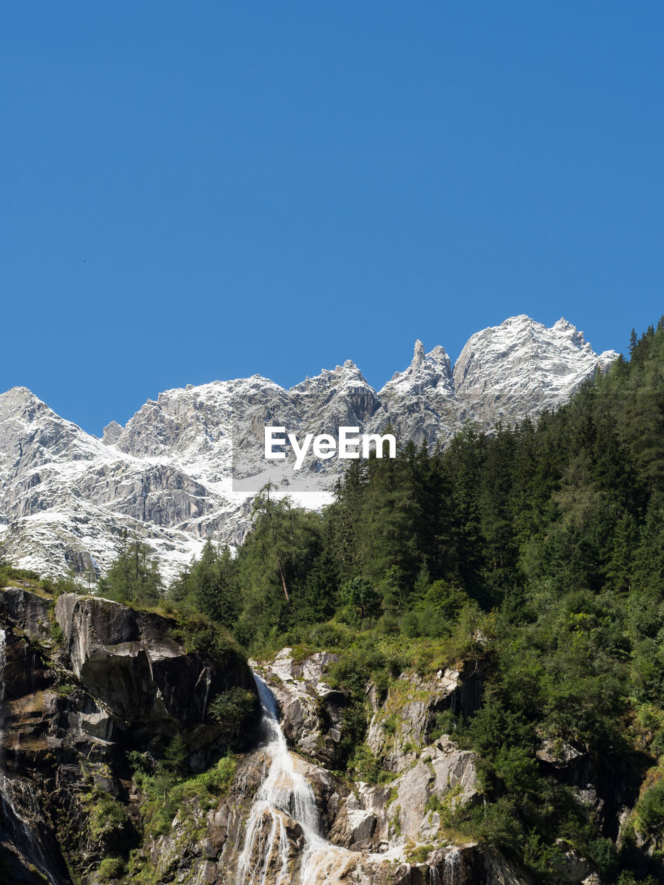 LOW ANGLE VIEW OF SNOWCAPPED MOUNTAIN AGAINST BLUE SKY