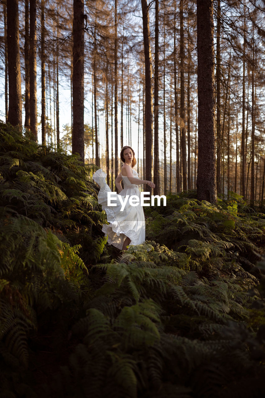 Woman in a forest wearing a white dress 