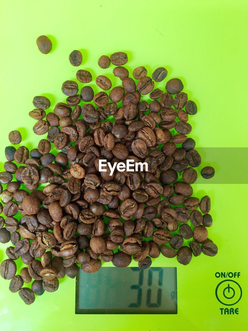 Close-up of coffee beans on green weight scale