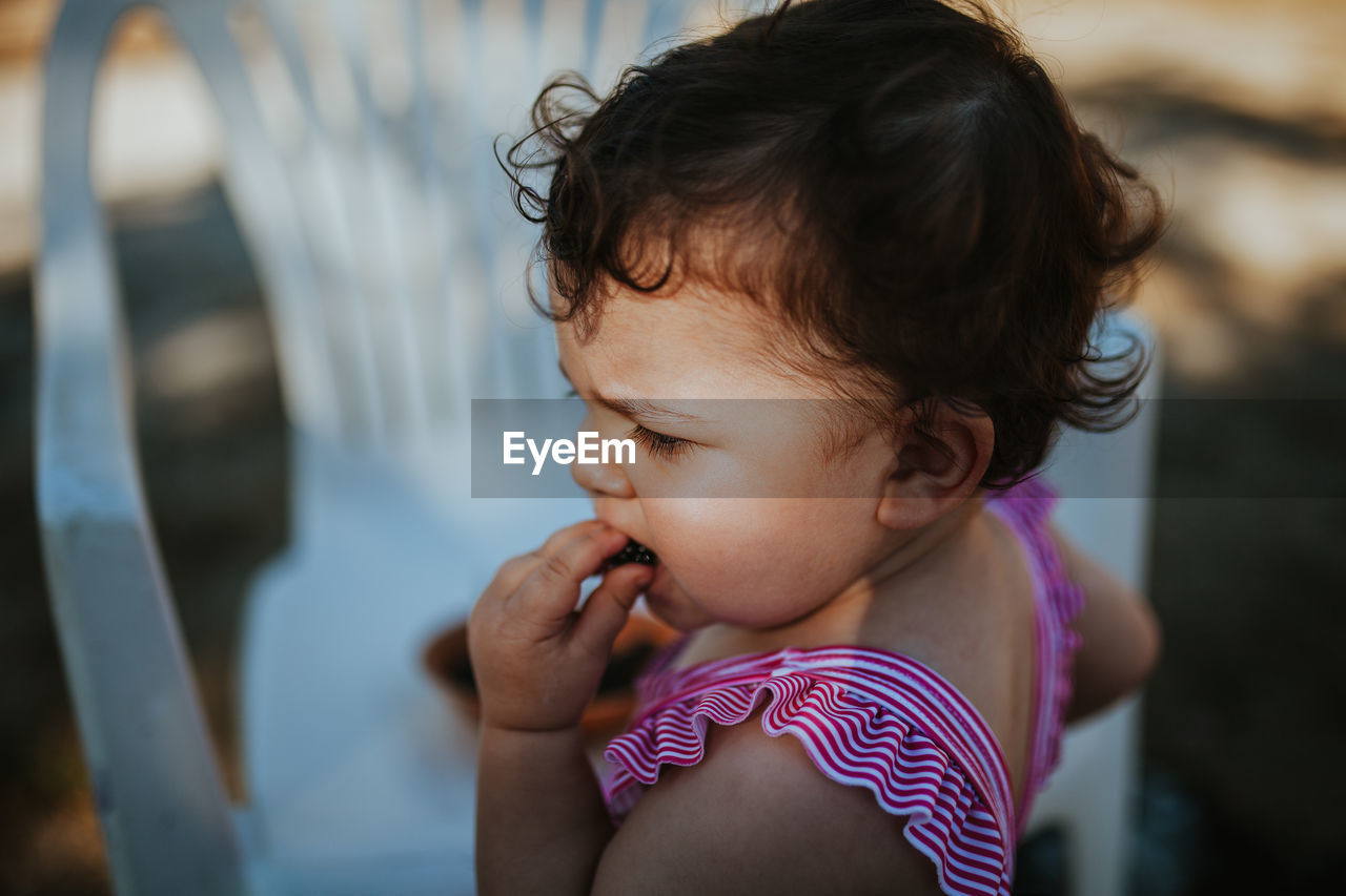 Close-up of baby girl eating blackberry