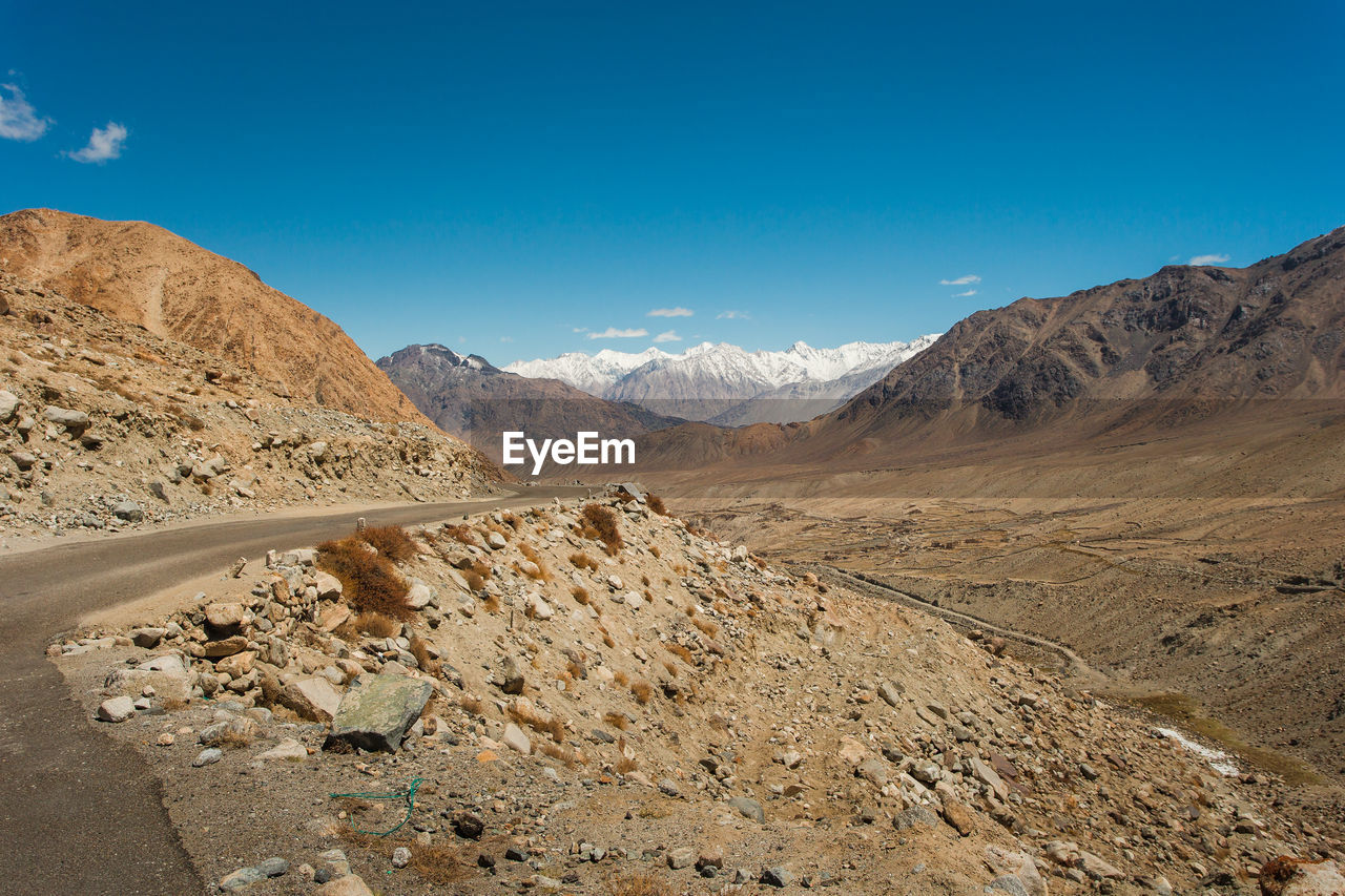 Scenic view of mountains against blue sky