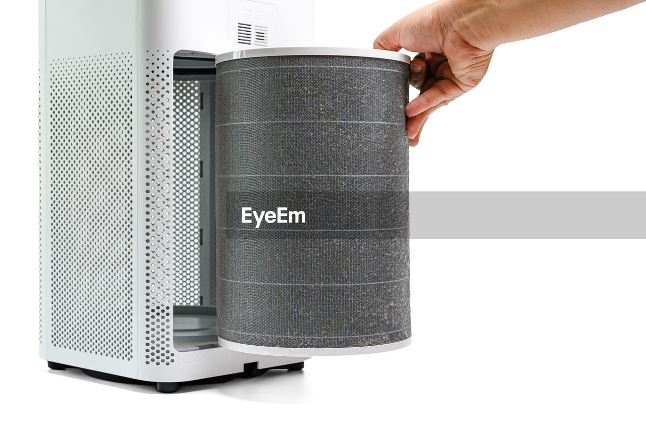 Man hold a old filter of the air purifier check with change filter in side air purifier f