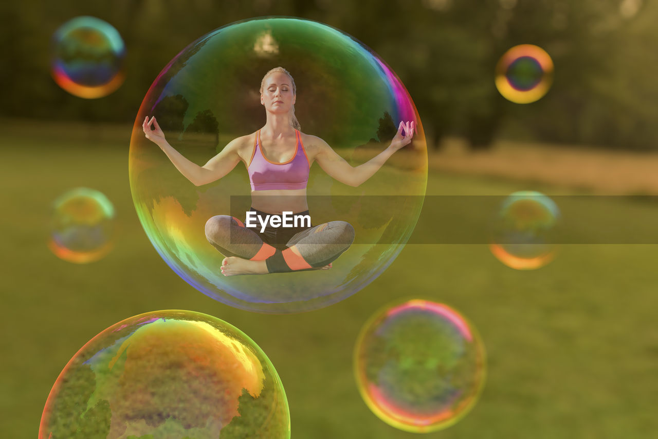 Digital composite image of woman doing yoga in bubble