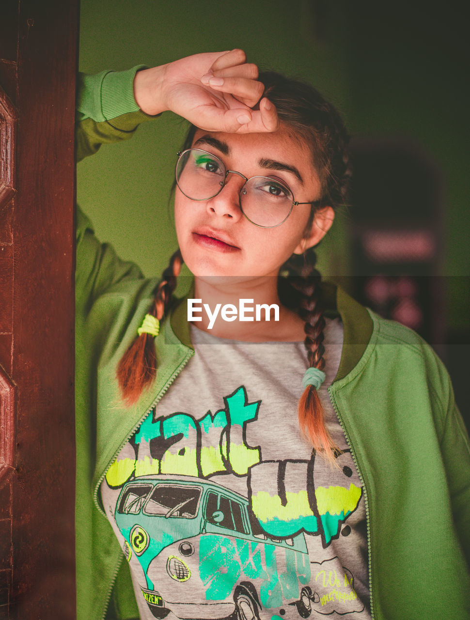 Portrait of young woman wearing eyeglasses while standing at home