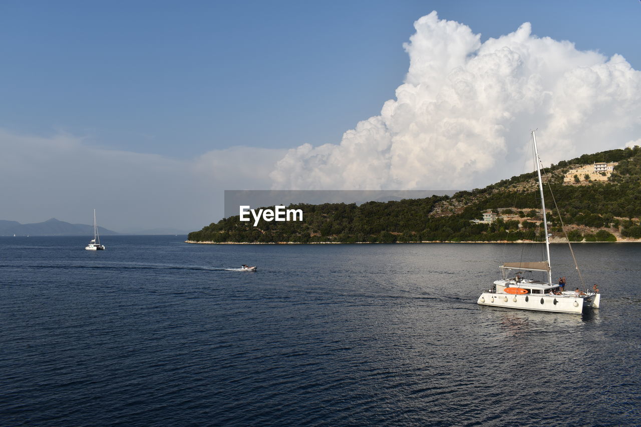 water, nautical vessel, sea, transportation, sky, mode of transportation, travel, cloud, ship, sailboat, nature, vehicle, sailing, land, scenics - nature, beauty in nature, boat, yacht, beach, holiday, travel destinations, vacation, trip, day, no people, environment, craft, coast, tourism, tranquility, blue, bay, tranquil scene, sailing ship, luxury, passenger ship, outdoors, tree, ocean, watercraft, mountain, coastline, idyllic, island, yachting, mast, cruise, landscape, horizon, non-urban scene, architecture, summer, shore, tropical climate, bay of water, journey, seascape