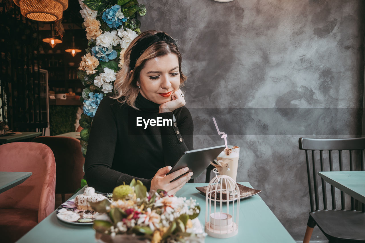 WOMAN SITTING ON TABLE IN RESTAURANT