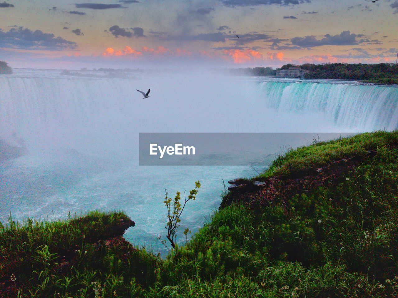 SCENIC VIEW OF WATERFALL AGAINST SKY