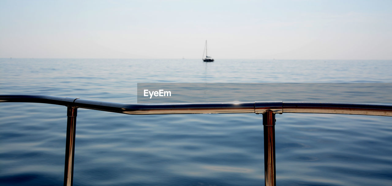 SAILBOAT SAILING IN SEA AGAINST CLEAR SKY