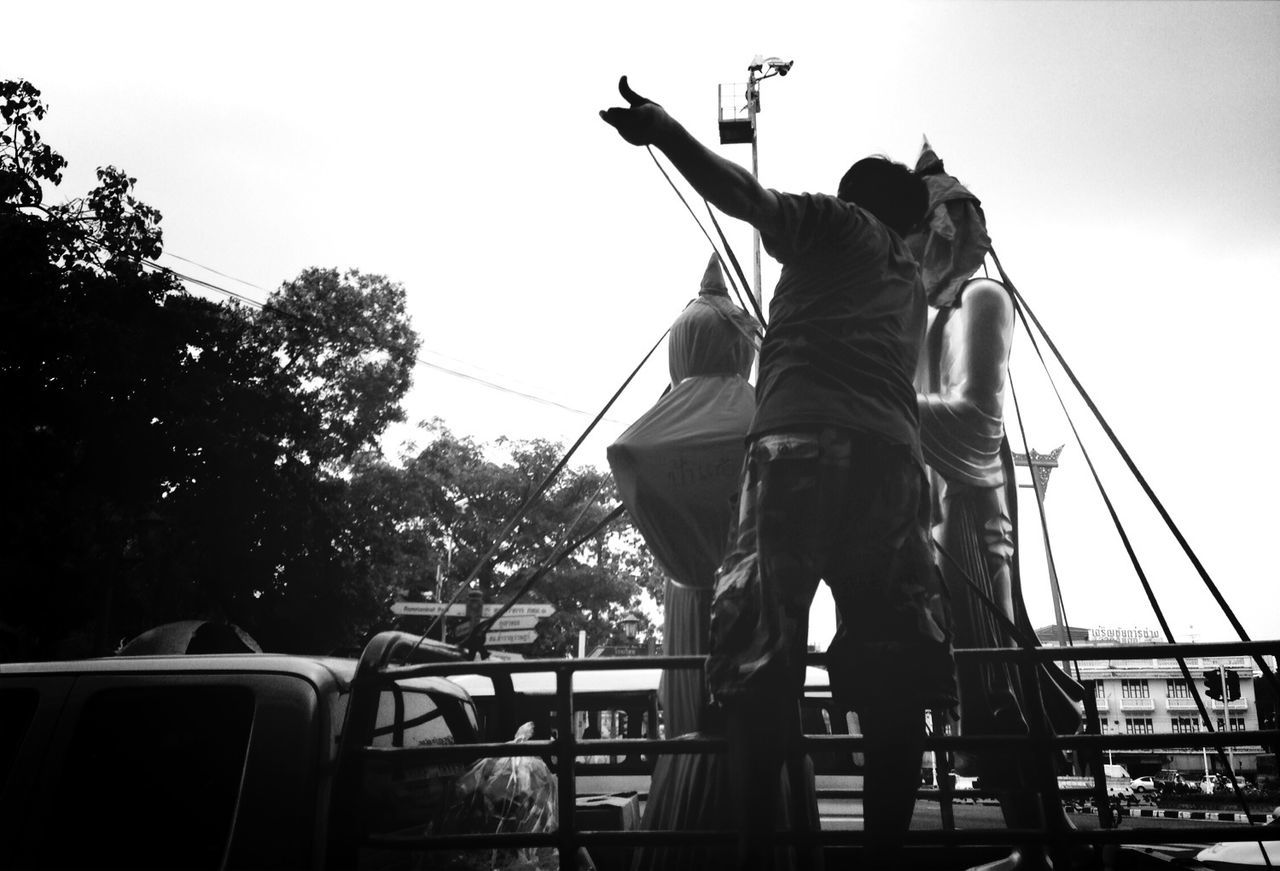 Rear view of man by covered statues