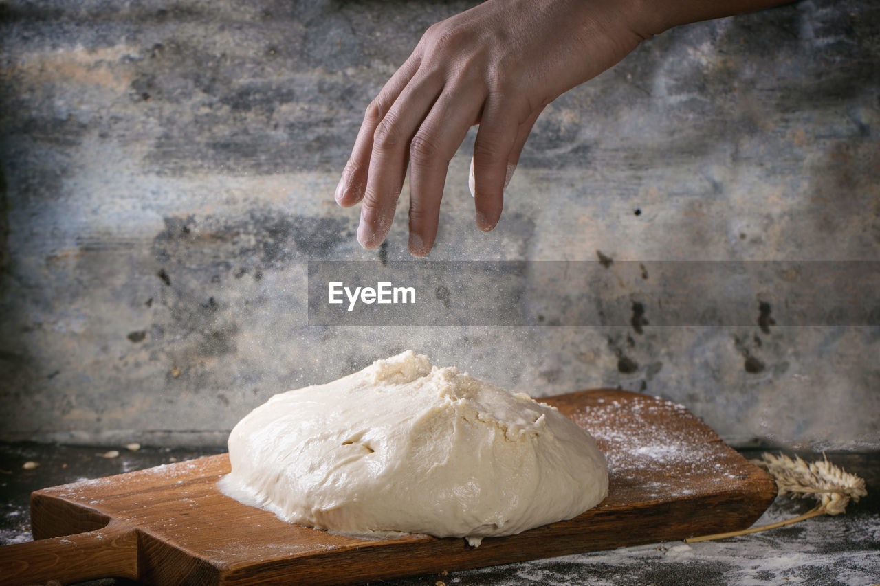 Close-up of human hand making dough