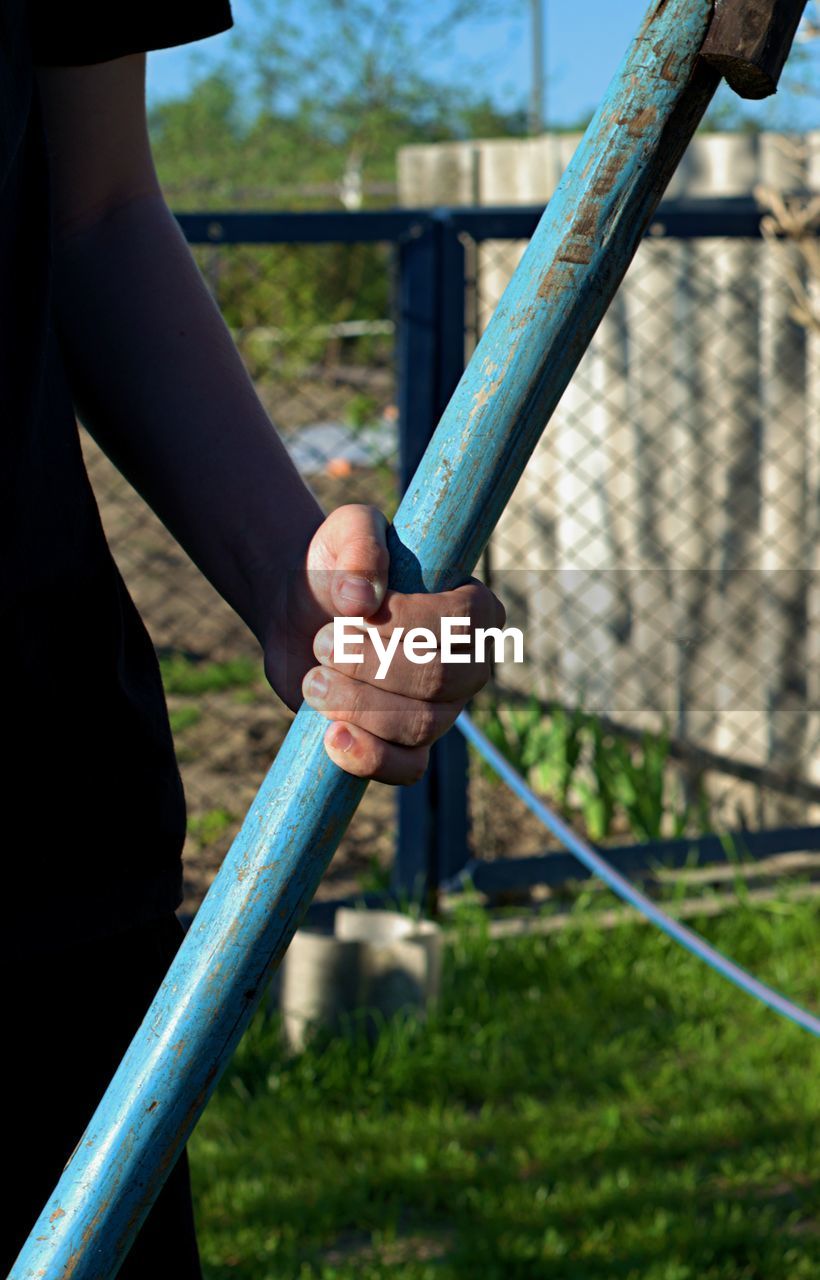 Cropped image of man holding hands on railing