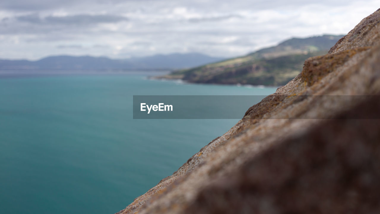 CLOSE-UP OF ROCKS ON SHORE AGAINST SKY