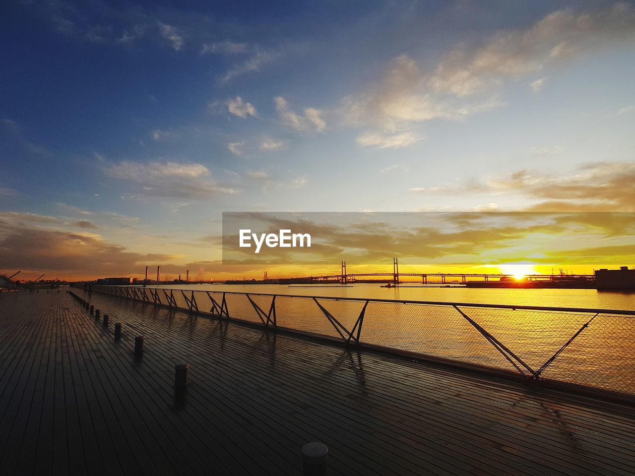 Pier over sea against sky during sunset