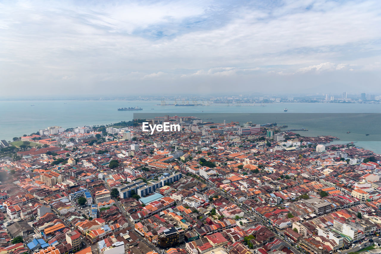 High angle view of townscape by sea against sky