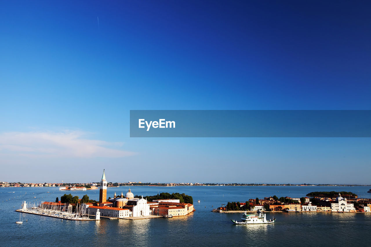 Mid distance view of san giorgio maggiore in grand canal against blue sky