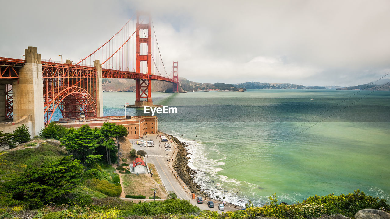 GOLDEN GATE BRIDGE OVER SEA AGAINST CLOUDY SKY