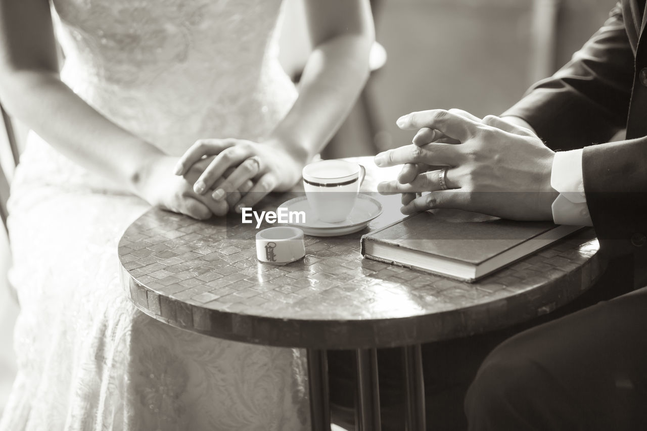 The two hands on the table of a newlywed couple who are about to get married.