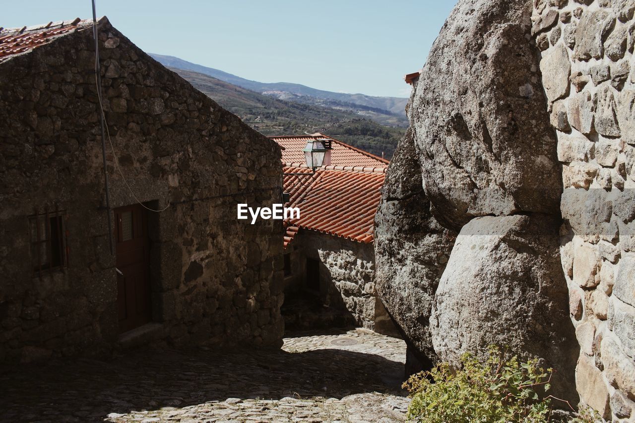 Stone wall of old building against sky