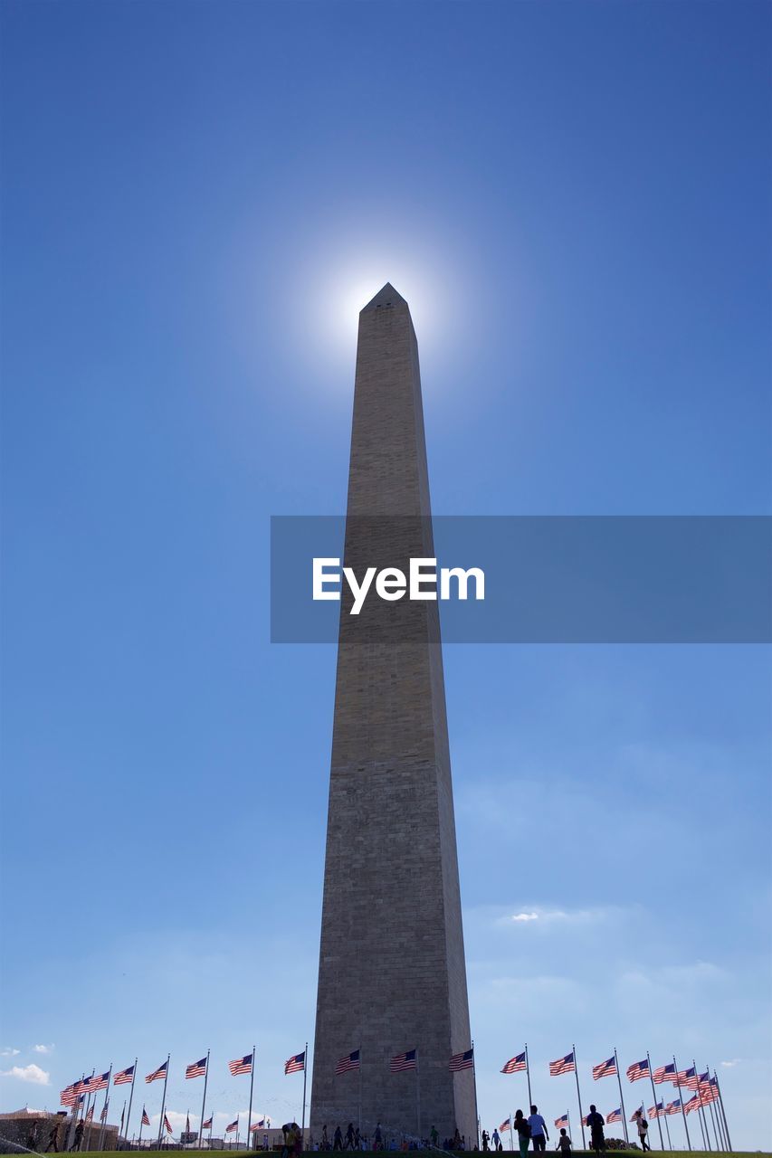 LOW ANGLE VIEW OF PEOPLE WALKING AGAINST CLEAR BLUE SKY