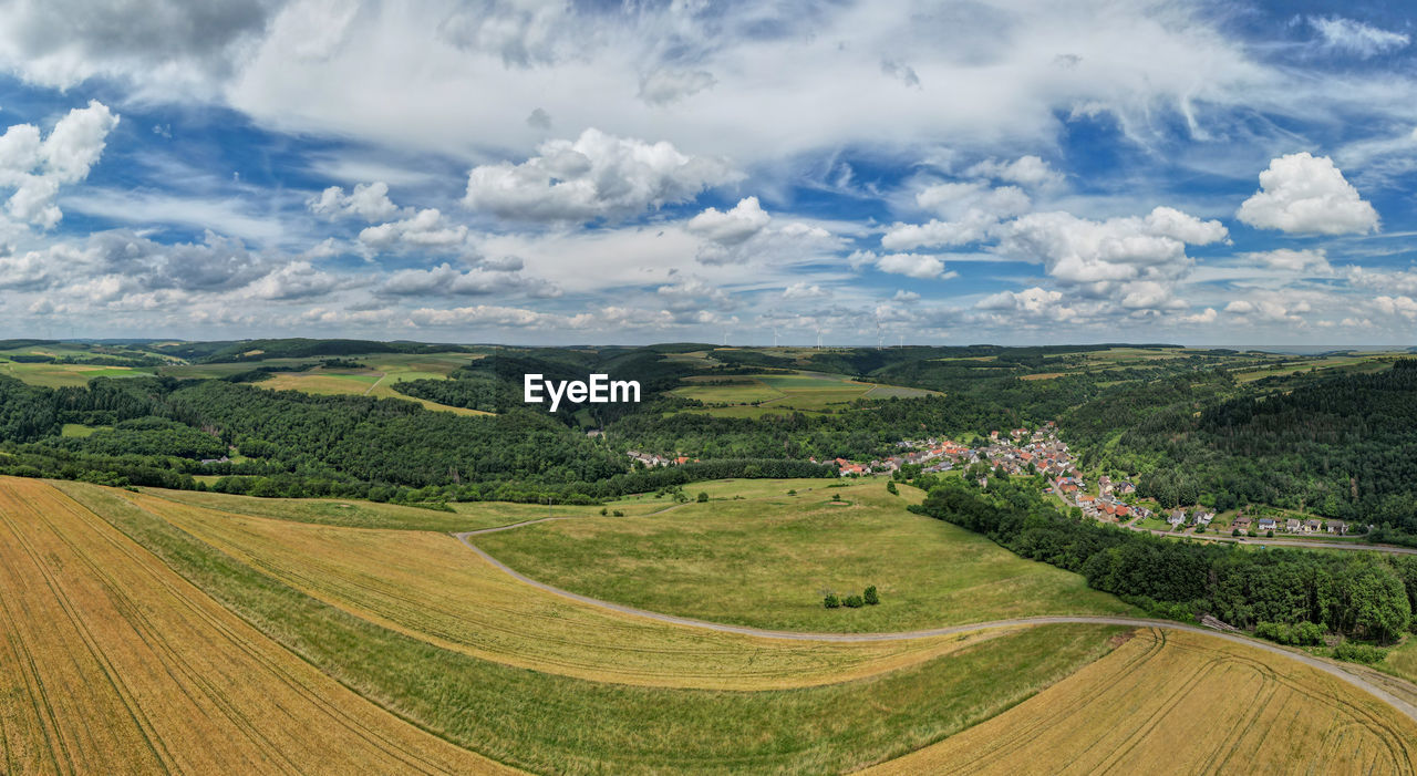 PANORAMIC SHOT OF AGRICULTURAL FIELD AGAINST SKY