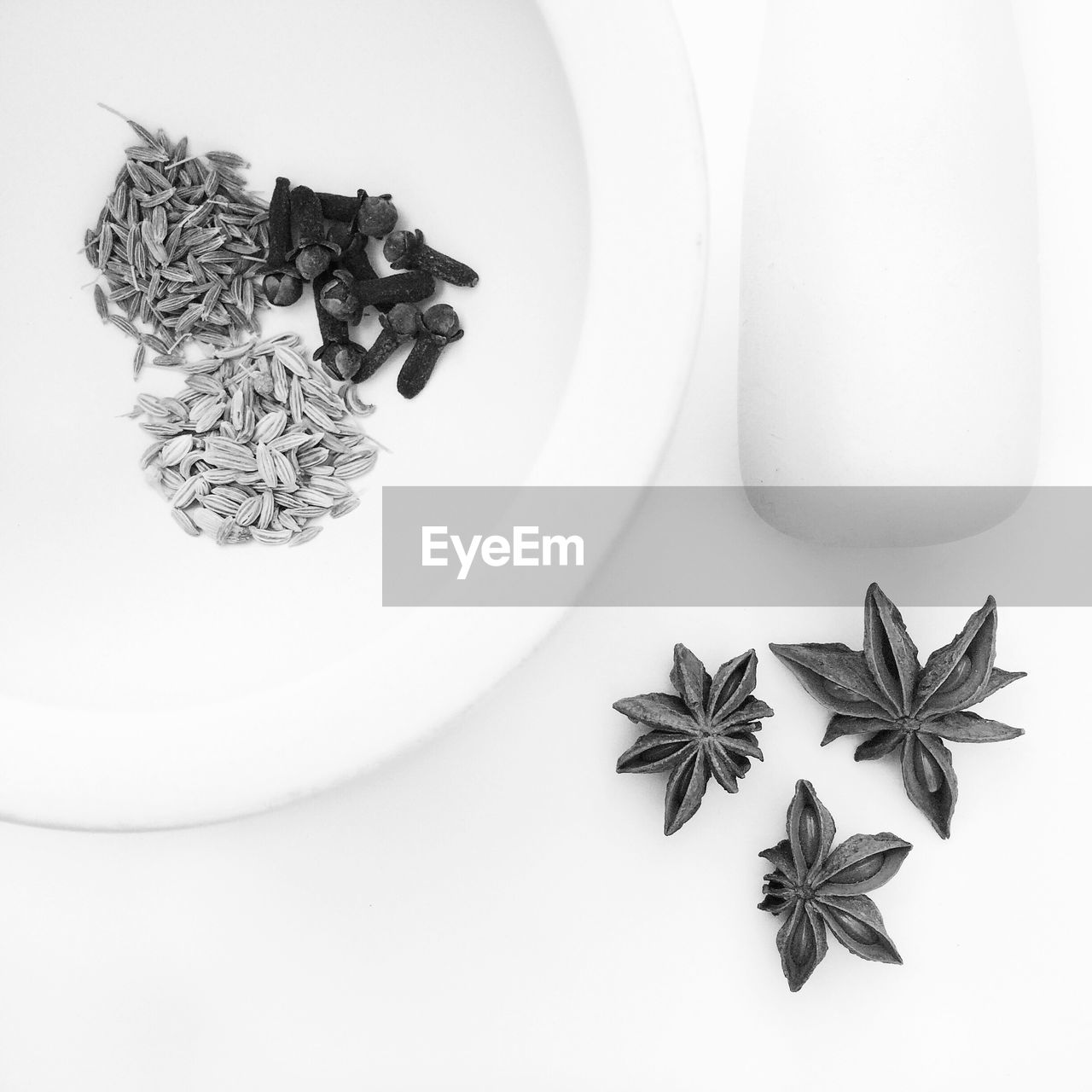 Directly above view of mortar and pestle with spices against white background