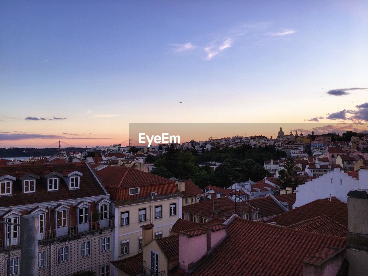 Houses in town against sky at sunset