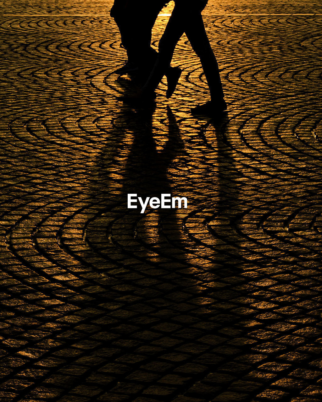 LOW SECTION OF SILHOUETTE PEOPLE WALKING ON STREET