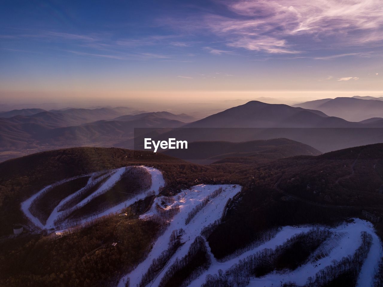 Scenic view of snow covered mountains against sky during sunset