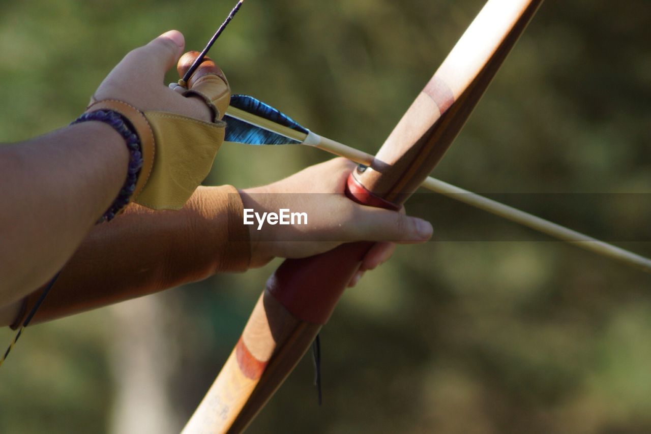 Cropped image of person holding archery bow