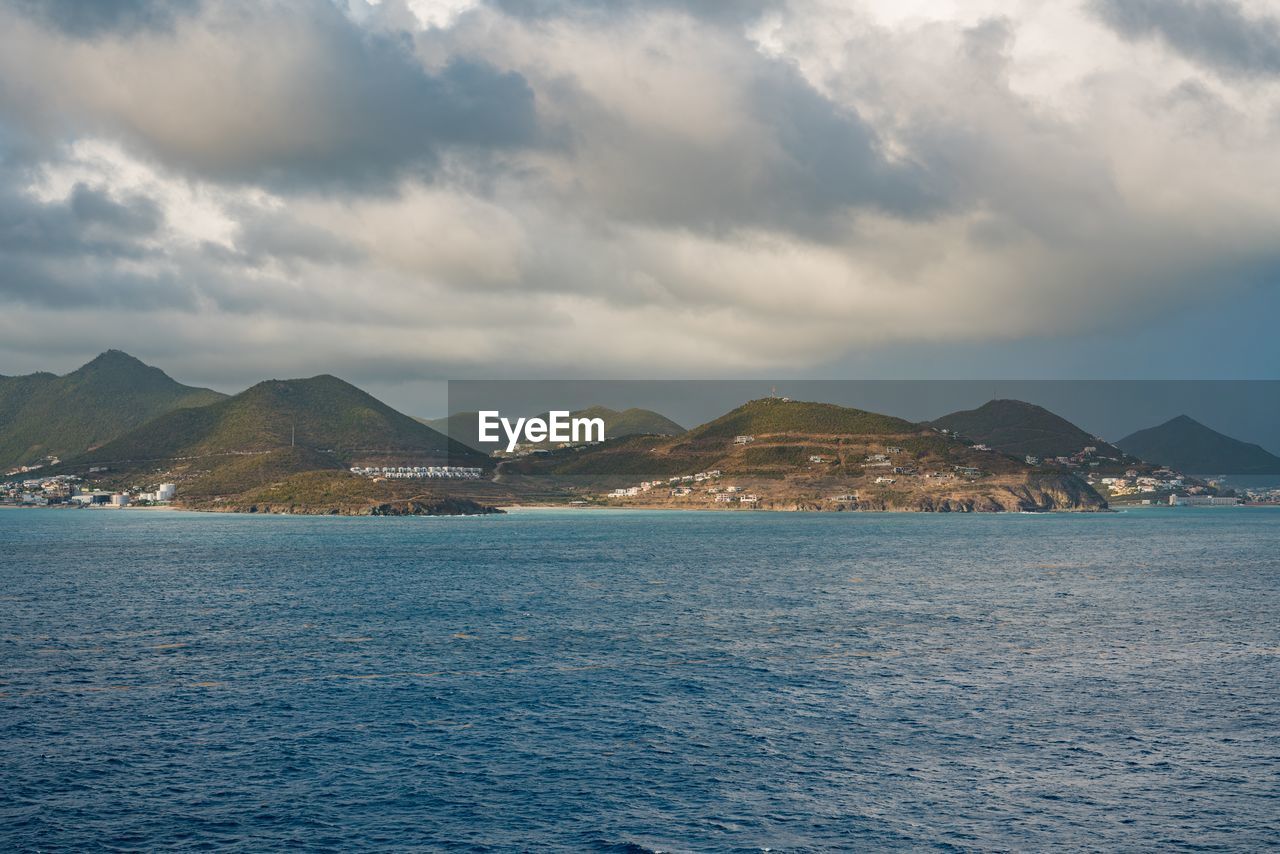 SEA BY MOUNTAINS AGAINST SKY